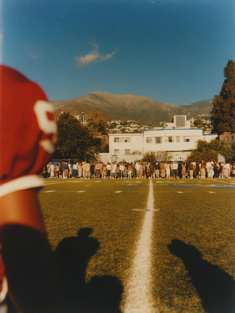 A player watches from the sideline as teams line up on a football field before a game