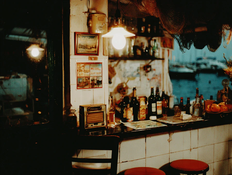 A dimly lit vintage bar counter lined with bottles and a warm hanging lamp